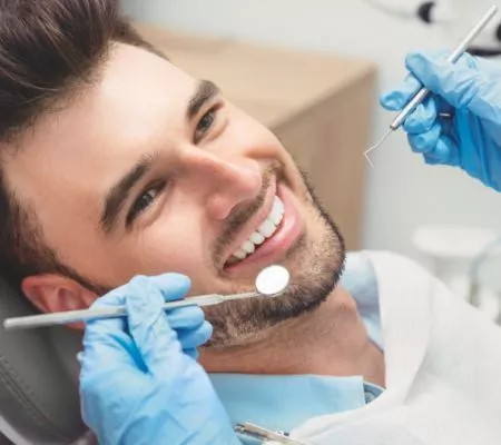 uśmiechnięty mężczyzna na badaniu stomatologicznym